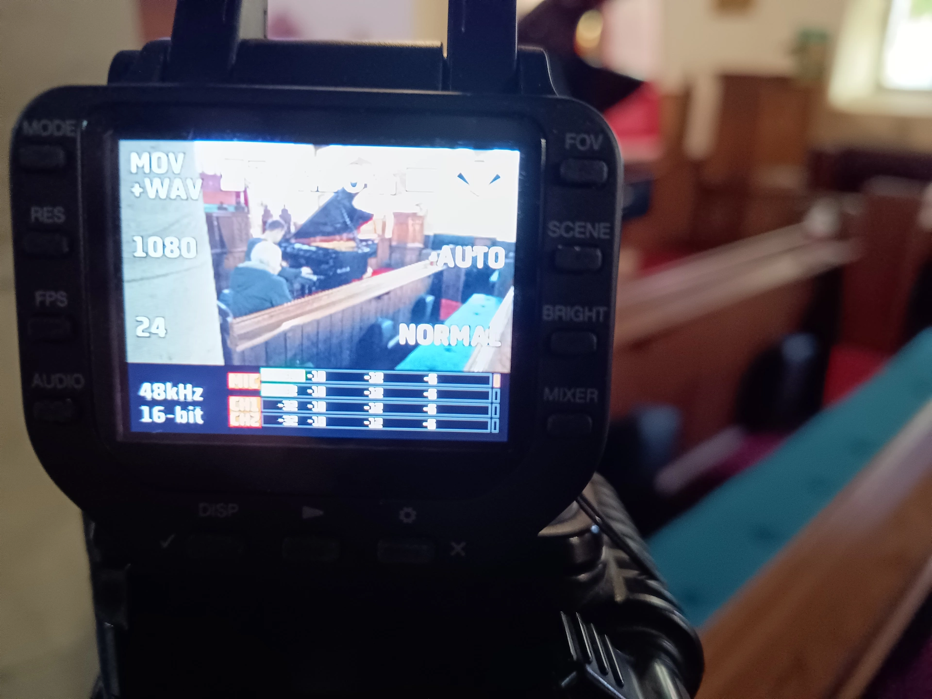 A shot of a video recorder screen showing Ethan at the piano