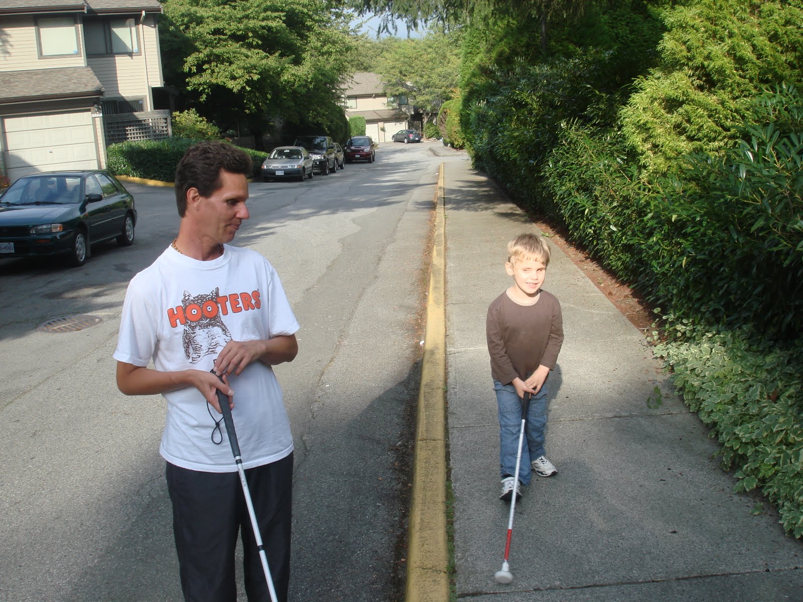 Ethan and Daniel kish walking down the street with their canes